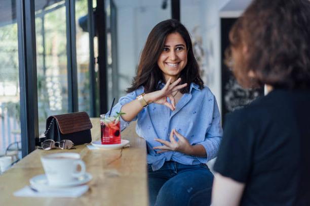 Two women smiling 和 speaking in sign language